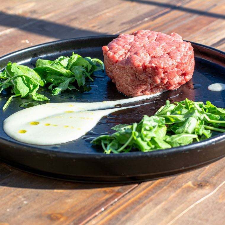 Tartare su piatto scuro al sole