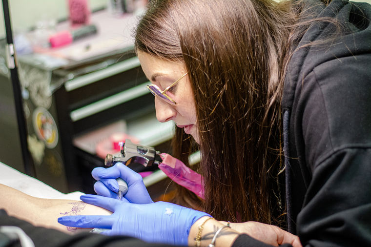 Tatuatrice concentrata sul lavoro